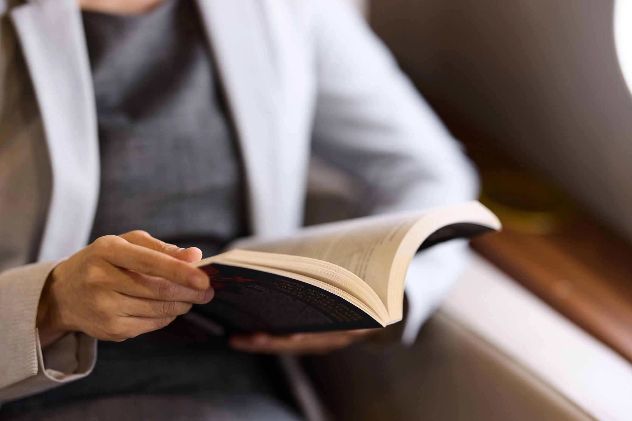 Person reading a book during travel